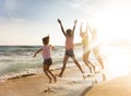 Happy family jumping on beach at sunset Royalty Free Stock Photo