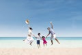 Happy family jumping at beach