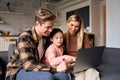 Happy family with kid using laptop computer sitting on couch. Royalty Free Stock Photo