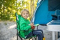 Happy family, kids, boy brothers and a dog, having breakfast in front of pitched tent on beach, while wild camping in Norway, Royalty Free Stock Photo