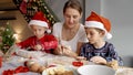 Happy family with kids cooking and preparing cookies for Santa on Christmas morning. Winter holidays, celebrations and Royalty Free Stock Photo