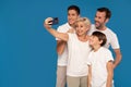 Happy family with kids have fun making selfies on the blue studio background Royalty Free Stock Photo