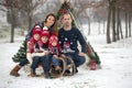 Happy family with kids, having fun outdoor in the snow on Christmas, playing with sledge Royalty Free Stock Photo