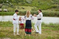 Happy family with kids in traditional romanian clothes dancing outside. Royalty Free Stock Photo