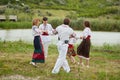 Happy family with kids in traditional romanian clothes. Father, mother, son and daughters dancing outside. Royalty Free Stock Photo