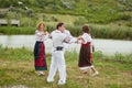 Happy family with kids in traditional romanian dress in a countryside dancing outside. Royalty Free Stock Photo