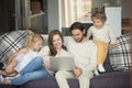 Happy family with kids using laptop on sofa at home