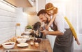 Happy family in kitchen. Father and child daughter knead dough a