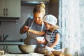 Happy family in kitchen. mother and child preparing dough, bake