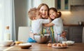 Happy family in kitchen. mother and children preparing dough, bake cookies