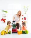 Happy family in the kitchen. Mother and children are preparing the vegetables and fruit. Royalty Free Stock Photo