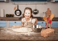 Happy family in the kitchen. Mother is showing her daughter bakery they have made together. Homemade food, little helper