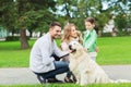 Happy family with labrador retriever dog in park Royalty Free Stock Photo