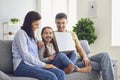 Happy family laptop online. Parents and a kid girl smiling at a laptop at their leisure in a weekend at home. Royalty Free Stock Photo