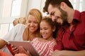 Happy Family Laughing Looking At Video On Tablet Computer Royalty Free Stock Photo