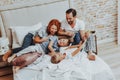 Happy family laughing while playing together in bed Royalty Free Stock Photo