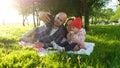 Happy family is laying on the grass and doing selfie with a baby at sunset in the park. Father and mother take pictures Royalty Free Stock Photo