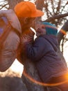 Happy family leisure, father and child. Little girl with long braided hair portrait in spring park on a tree on sunset Royalty Free Stock Photo