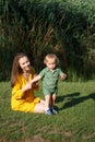 Happy family leisure outdoors. Portrait of smiling young woman and little toddler son. Reeds in the background. Mom and child Royalty Free Stock Photo