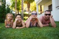 A happy family lies on the grass in a tropical paradise. Summer family sea vacation. Bottom view. Royalty Free Stock Photo