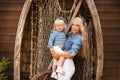 Happy family lifestyle concept. Family look. Portrait of Blonde Mother holding her daughter hugging by boat with fishing net.