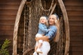 Happy family lifestyle concept. Family look. Portrait of Blonde Mother holding her daughter hugging by boat with fishing net.