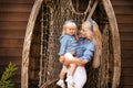 Happy family lifestyle concept. Family look. Portrait of Blonde Mother holding her daughter hugging by boat with fishing net.