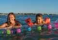 Happy family lifestyle.  Smiling young mother and son jumping and splashing with fun in breaking waves Royalty Free Stock Photo