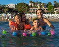 Happy family lifestyle. Young mothers with children jumping and splashing with fun in breaking waves. Summer travel, water sport Royalty Free Stock Photo