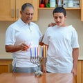 Happy family is lighting a candle celebrating together Jewish holiday Hanukkah. Royalty Free Stock Photo