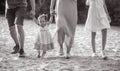 A happy family with little baby girl goes and holds hands while walking Royalty Free Stock Photo