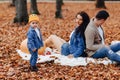 Happy family with little cute child in park on yellow leaf with Royalty Free Stock Photo