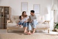 Happy family with little daughter sitting on sofa in room Royalty Free Stock Photo