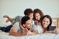 Happy family with little kids taking selfies on a cellphone while lying on bed at home. Smiling couple bonding with son Royalty Free Stock Photo
