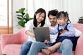 Happy family in living room, Chubby little girl daughter with her mother and father using tablet in living room. Kid spending Royalty Free Stock Photo