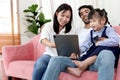 Happy family in living room, Chubby little girl daughter with her mother and father using tablet in living room. Kid spending Royalty Free Stock Photo