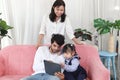 Happy family in living room, Chubby little girl daughter with her mother and father using tablet in living room. Kid spending Royalty Free Stock Photo