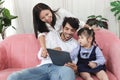 Happy family in living room, Chubby little girl daughter with her mother and father using tablet in living room. Kid spending Royalty Free Stock Photo