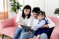 Happy family in living room, Chubby little girl daughter with her mother and father using tablet in living room. Kid spending Royalty Free Stock Photo