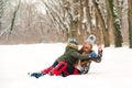 Happy family liying in the snow in winter time. Young mother having fun with son outdoors Royalty Free Stock Photo