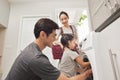 Happy Family loading clothes into washing machine in home Royalty Free Stock Photo