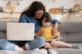 Mom and kid son use tablet sit on sofa, smiling mother help child with e-learning lessons or games Royalty Free Stock Photo