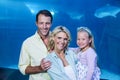 Happy family looking at camera beside the fish tank Royalty Free Stock Photo