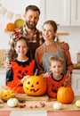 Happy family looking at camera while make jack-o-lantern from pumpkin, getting ready for halloween Royalty Free Stock Photo