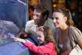 Happy family looking at fish tank Royalty Free Stock Photo