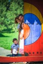 Happy family looks out from behind the door. Mom, dad, daughter and little son for a walk in the park. Smiling parents play hide- Royalty Free Stock Photo