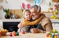 Happy family loving grandfather and cute little boy grandson embracing while painting Easter eggs Royalty Free Stock Photo