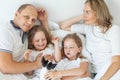 Happy family lying down on bed at home Royalty Free Stock Photo