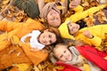 Happy family lying on dry leaves in autumn park Royalty Free Stock Photo