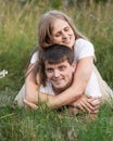 Happy family lying in grass and enjoying walk together at meadow in summer Royalty Free Stock Photo